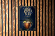 A sign for a vodka buck cocktail is displayed on a wooden wall.