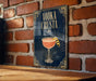 A sign with the text "VODKA CRUSTA" and an illustration of a cocktail glass with a lemon twist, mounted on a brick wall.