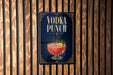 A sign for a vodka punch is displayed on a wooden wall.