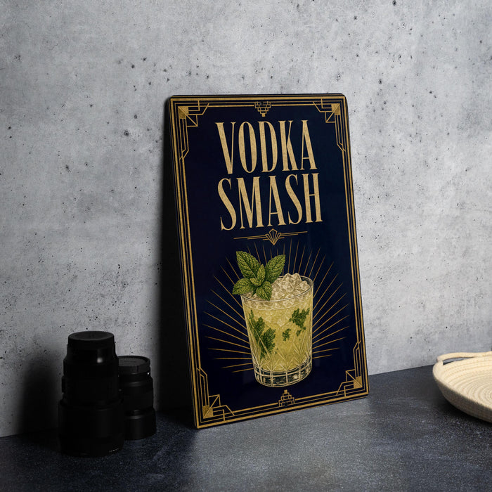 a framed illustration of a cocktail with the text "VODKA SMASH" on it, placed on a table next to some black containers.