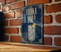 A sign with the text "VODKA SODA" and an illustration of a glass of vodka soda is displayed on a brick wall.