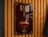 A sign with the number "8" and an illustration of a cocktail on a wooden wall.