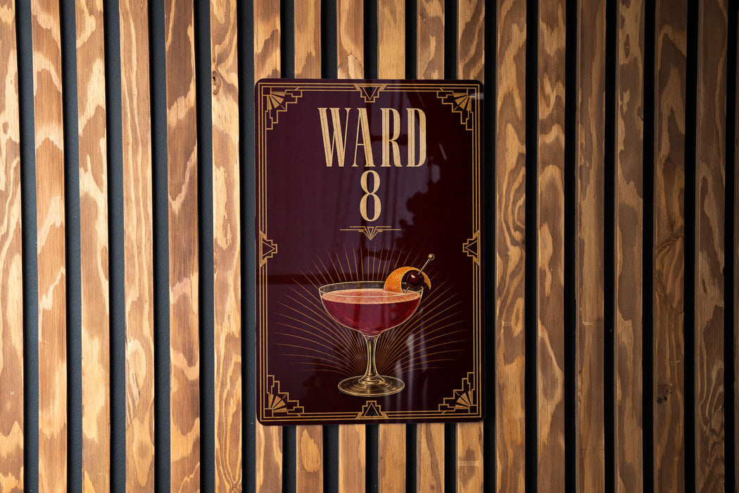 A sign with the number "8" and an illustration of a cocktail is displayed on a wooden wall.