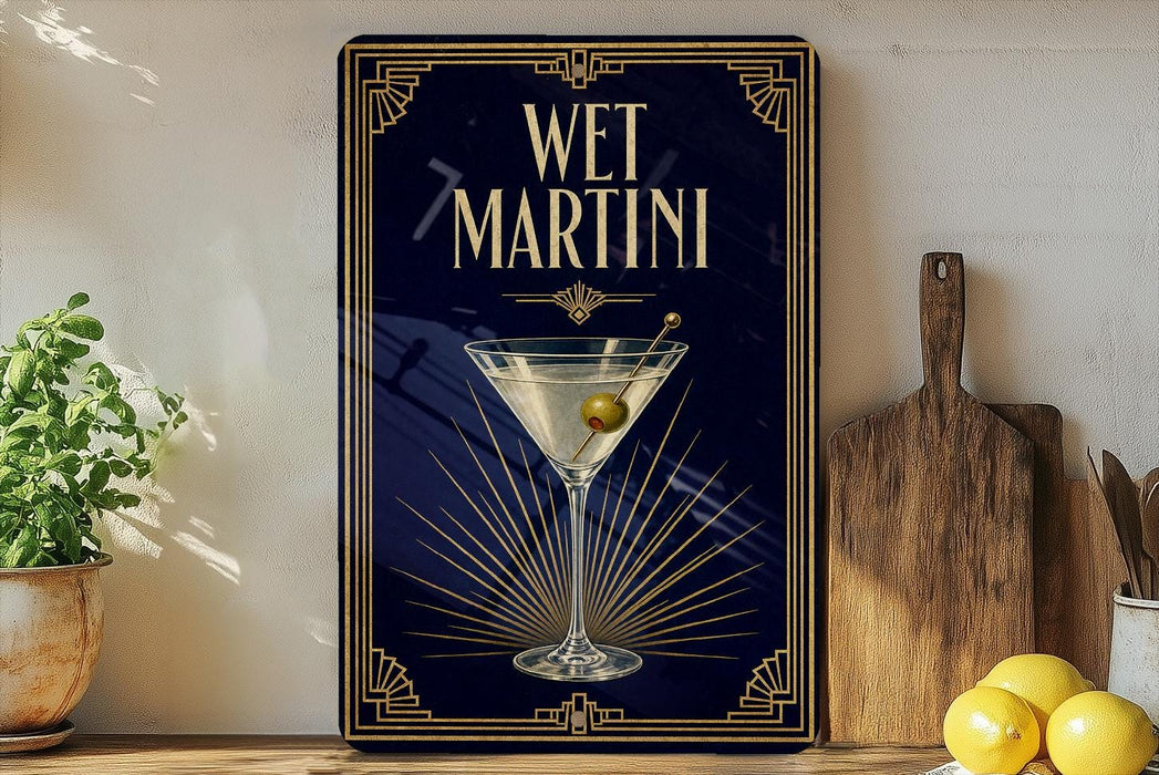 A framed poster of a martini glass with a green olive on a dark blue background, accompanied by the text "WET MARTINI" in a decorative font.
