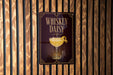 A sign for "Whiskey Daisy" cocktail is displayed on a wooden wall.