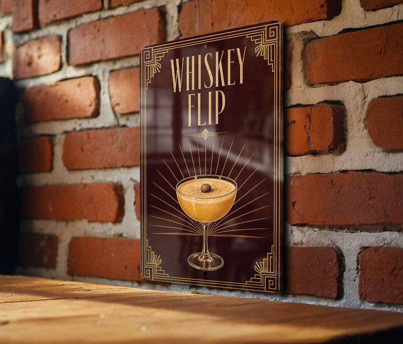 A poster or sign with the text "WHISKEY FLIP" and an illustration of a cocktail in a glass, mounted on a brick wall.