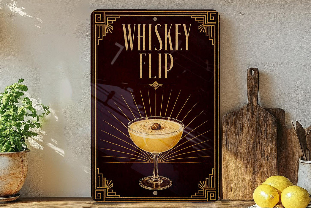 A decorative sign with the text "WHISKEY FLIP" and an illustration of a cocktail glass with a lemon slice, placed on a wooden surface next to a potted plant and a cutting board.