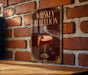 A sign with the text "WHISKEY REBLLION" and an illustration of a cocktail is displayed on a brick wall.