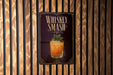 A poster advertising a whiskey smash cocktail is displayed on a wooden wall.
