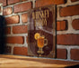 A sign with the text "Whiskey Toddy" and an illustration of a glass of whiskey with a slice of lemon.