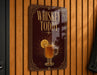 A sign that reads "Whiskey Toddy" with an illustration of a glass of whiskey and a slice of lemon.