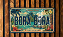 A vintage license plate with the text "BORA BORA" and a tropical landscape featuring palm trees, mountains, and a body of water.