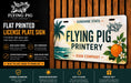 The image is an advertisement for a flat-printed license plate sign from the Flying Pig Sign Company. It features a tropical design with a pig, palm tree, and an orange, and highlights the sign's durability, high gloss finish, custom design options, and ease of hanging.