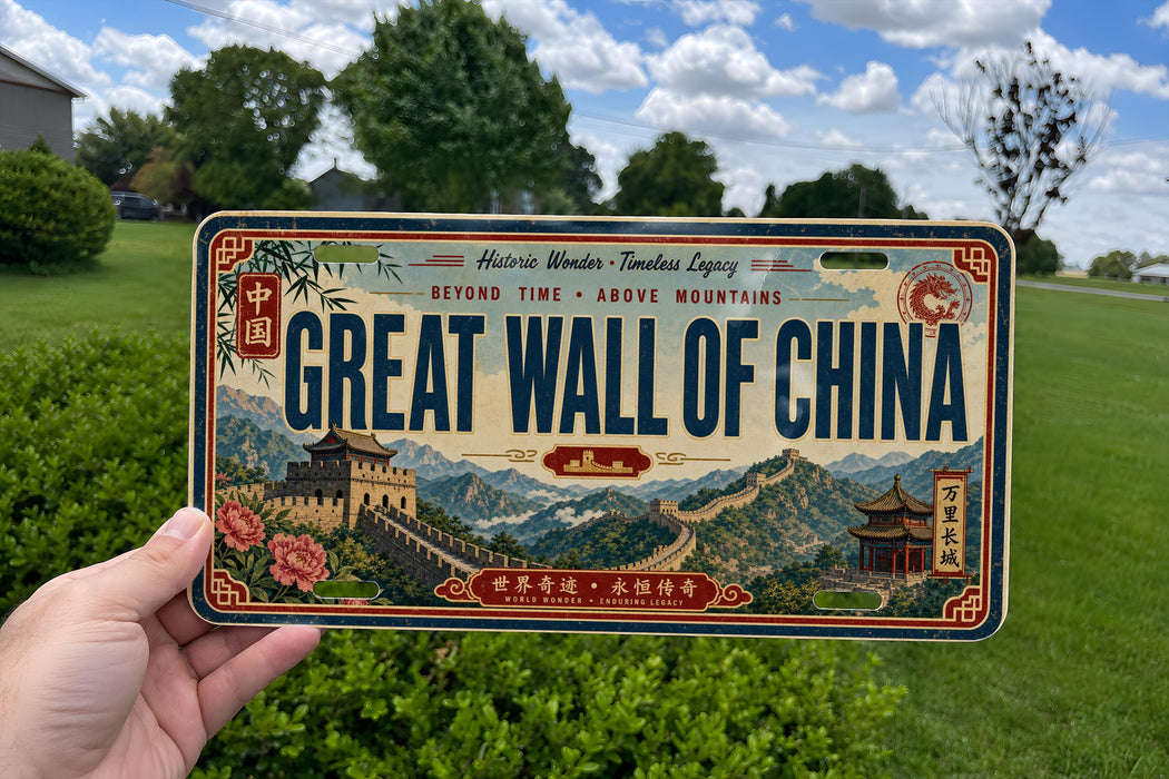 A person is holding a license plate with a picture of the Great Wall of China on it.
