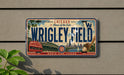 A vintage Chicago Cubs baseball plate with the text "Chicago Home of the Cubs" and "WRIGLEY FIELD" printed on it, along with an illustration of the baseball field and a baseball bat.