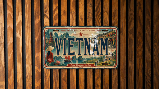 A vintage license plate from Vietnam, featuring an illustration of the country's landscape and culture, is displayed on a wooden wall.