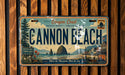 The image is a license plate from Oregon, featuring the name "Cannon Beach" and a scenic mountain landscape.