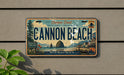 a license plate with a scenic coastal landscape, including mountains, a beach, and a body of water.