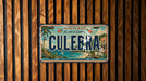 A vintage license plate from Puerto Rico with the word "Culebra" prominently displayed, mounted on a wooden wall.