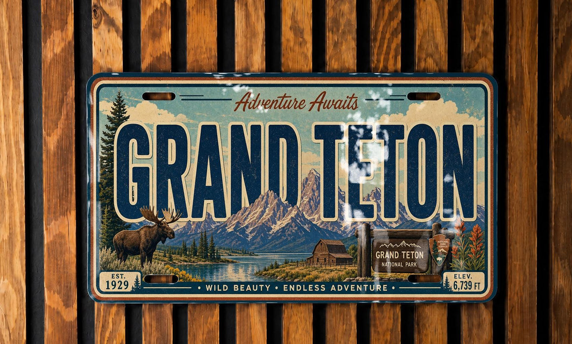 A vintage license plate from Grand Teton National Park, featuring a scenic mountain landscape with a moose and cabin in the foreground.