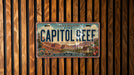 A vintage license plate from Utah, specifically the Capitol Reef National Park, is displayed against a wooden background.