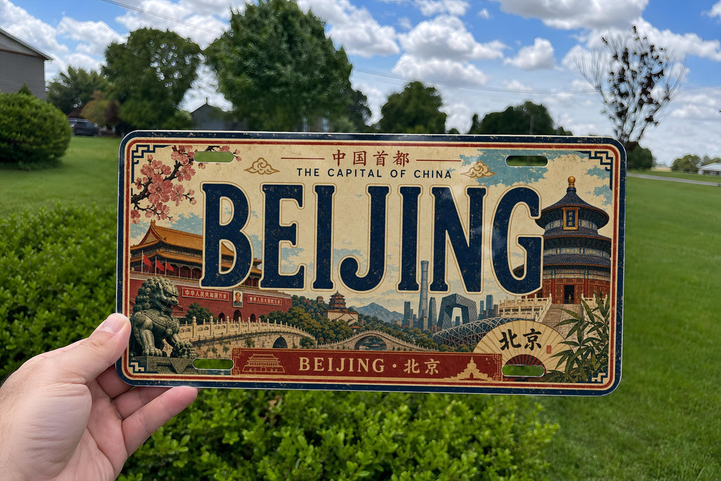A person is holding a license plate that says "Beijing" with various landmarks and scenes of the city of Beijing, China, depicted on the plate.