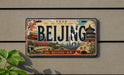 A vintage-style license plate with the word "BEIJING" prominently displayed, featuring various landmarks and scenes from the city of Beijing, China.
