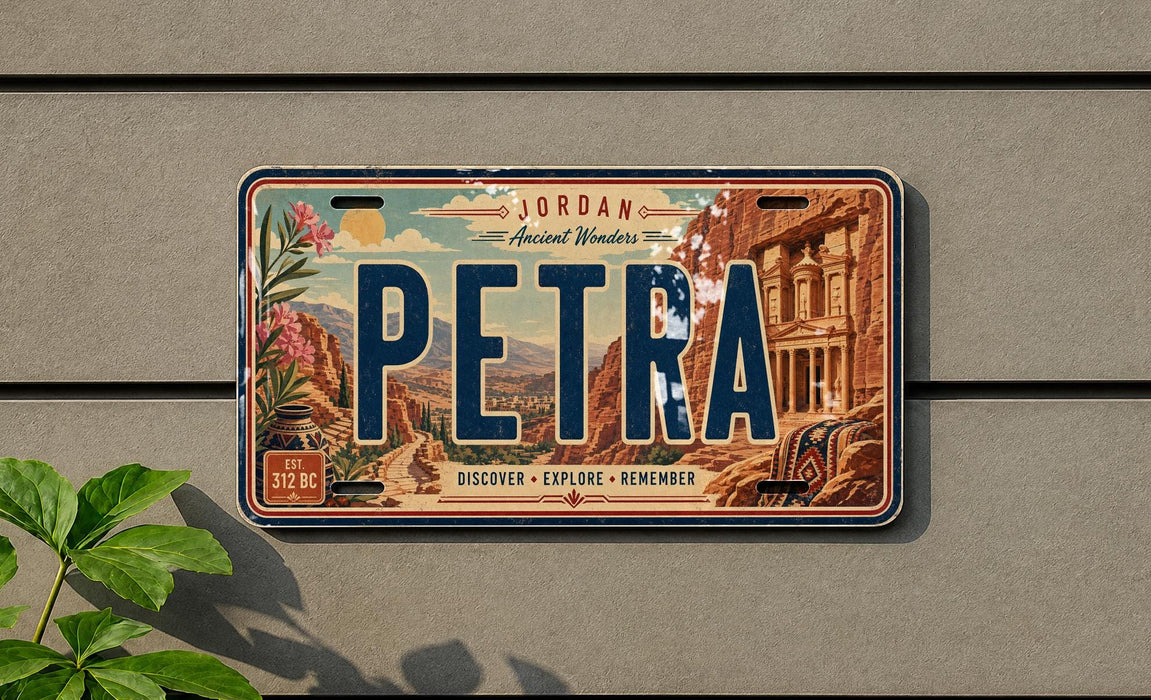 A vintage-style license plate with the word "PETRA" prominently displayed, featuring an illustration of a desert landscape with a building and mountains in the background.