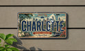A license plate with the text "CHARLOTTE NORTH CAROLINA City of Oaks EST. 1768" is displayed on a wall.