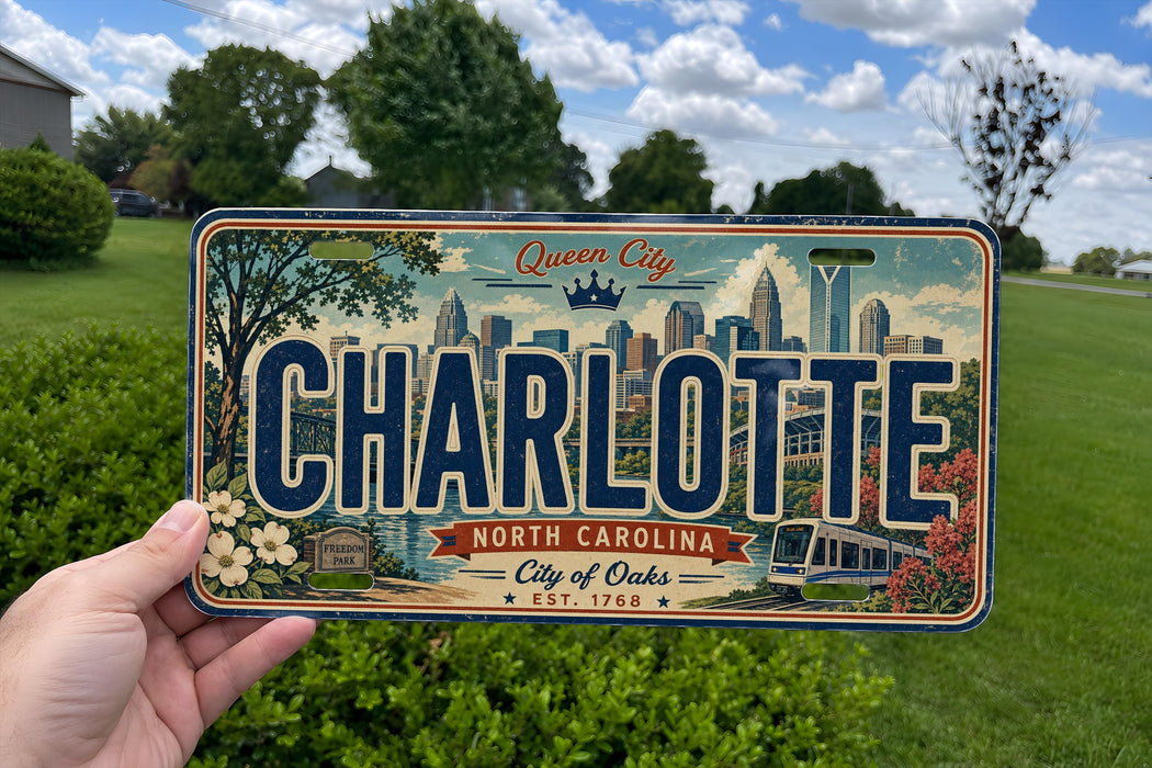A person is holding a license plate with the text "CHARLOTTE NORTH CAROLINA City of Oaks EST. 1768" on it, with a cityscape and other elements visible on the plate.