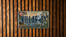 A vintage license plate from Ireland with the word "KILLARNEY" prominently displayed, hanging on a wooden wall.