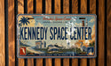 A vintage license plate with the text "Florida's Space Coast" and "KENNEDY SPACE CENTER" printed on it, along with various space-related imagery such as a rocket launch, a satellite, and a space shuttle.