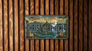 A vintage license plate with a design featuring the Christ the Redeemer statue and the words "Christ the Redeemer" in a tropical setting.