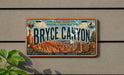 A vintage license plate with the text "Bryce Canyon" and various icons related to nature and exploration, mounted on a wall.