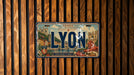 A license plate with the word "LYON" prominently displayed, featuring an illustration of a cityscape and a lion.