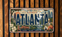 A vintage license plate from Georgia, featuring the city of Atlanta with various landmarks and symbols.