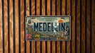 A vintage license plate from Medellín, Colombia, with a colorful illustration of the city and landmarks.
