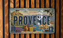 A vintage license plate from Provence, France, featuring a scenic illustration of the region's landscape and culture.
