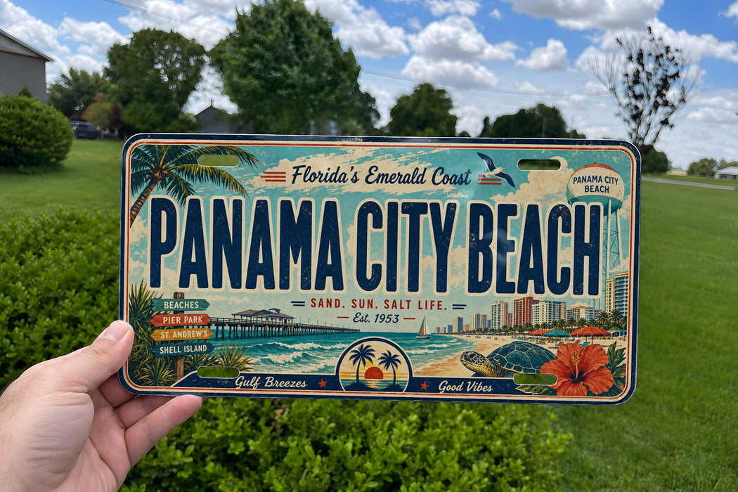 A person is holding a license plate with the text "Panama City Beach" on it, which is a tropical beach destination in Florida.