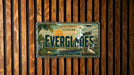 A vintage Everglades Florida license plate is displayed against a wooden background.