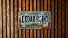 A license plate with the text "Cedar Point" and an illustration of Cedar Point amusement park, which is located in Seduction, Ohio, USA.