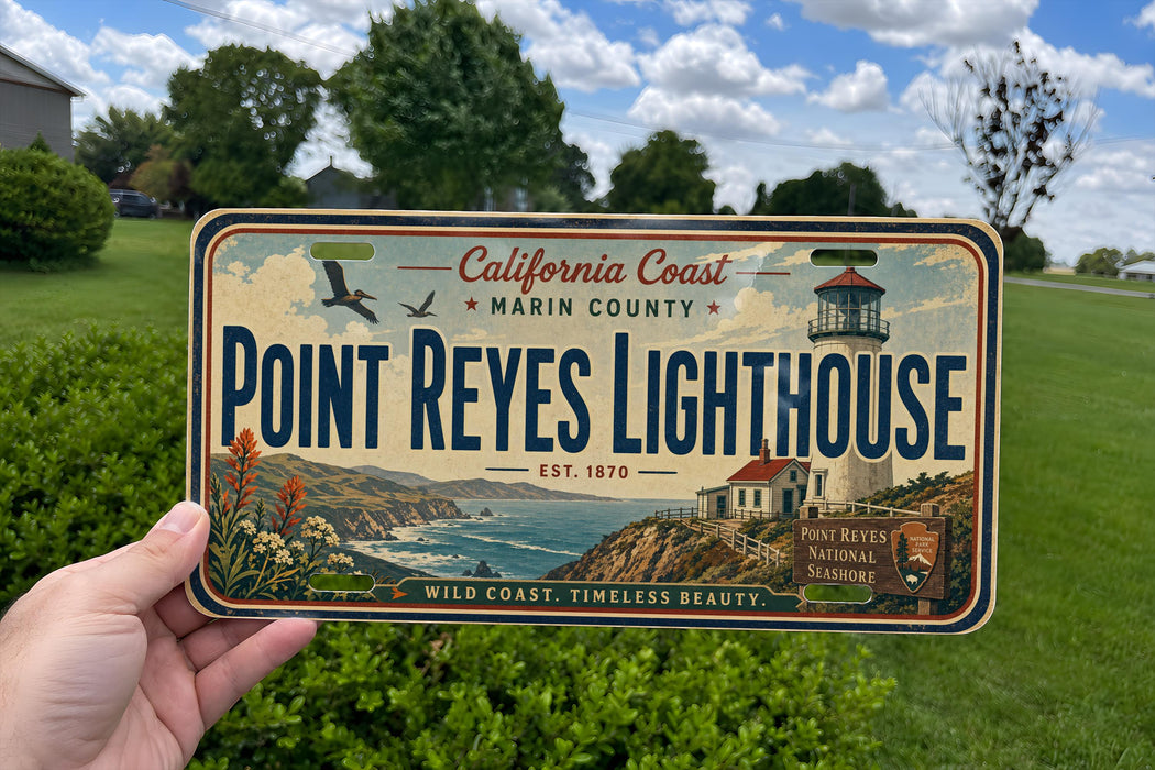 A person is holding a California Coast Marin County license plate that features the Point Reyes Lighthouse, a historic lighthouse located in Point Reyes National Seashore.