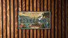 A vintage license plate with a coastal scene and the text "Heceta Head Lighthouse" is displayed on a wooden wall.