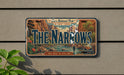A vintage license plate with a scenic mountain landscape and the text "The Narrows" is displayed on a wall.