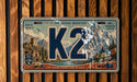 A vintage-style license plate with a mountain landscape and the text "K2" prominently displayed.