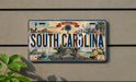 A license plate from South Carolina, featuring a vintage-style illustration of the state's landmarks and natural beauty.