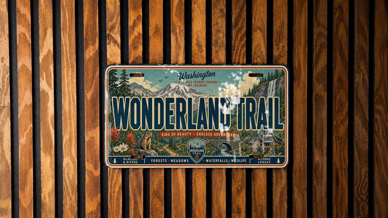 A license plate with a scenic mountain landscape and the text "Wonderland Trail" on it, mounted on a wooden wall.