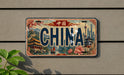 A decorative license plate with the word "CHINA" prominently displayed, featuring a scenic illustration of traditional Chinese architecture and landmarks.