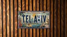 A license plate from Tel Aviv, Israel, with a vintage design featuring a beach scene and palm trees.