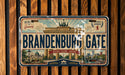 A vintage-style license plate from Berlin, Germany, with the text "Brandenburg Gate" prominently displayed.